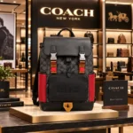 Coatch Charter Backpack in Black Signature Canvas with Red Leather Side Panels, Grey Flap & Multicolor Accent Straps (Black-Red) (58-1)