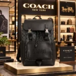 Coacch Charter Backpack in Signature Canvas with Embossed Logo Front Pocket, Leather Flap & Dual Buckle Closures (058-1)